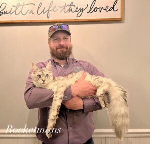 Rocketmans owner Matthew holding kitten graduate Patty Cakes